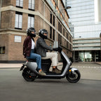 Deux personnes circulant en ville sur le scooter électrique Segway E150 S