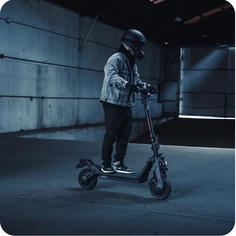 Conducteur à l'arrêt sur la trottinette électrique Segway GT3 E en environnement sombre