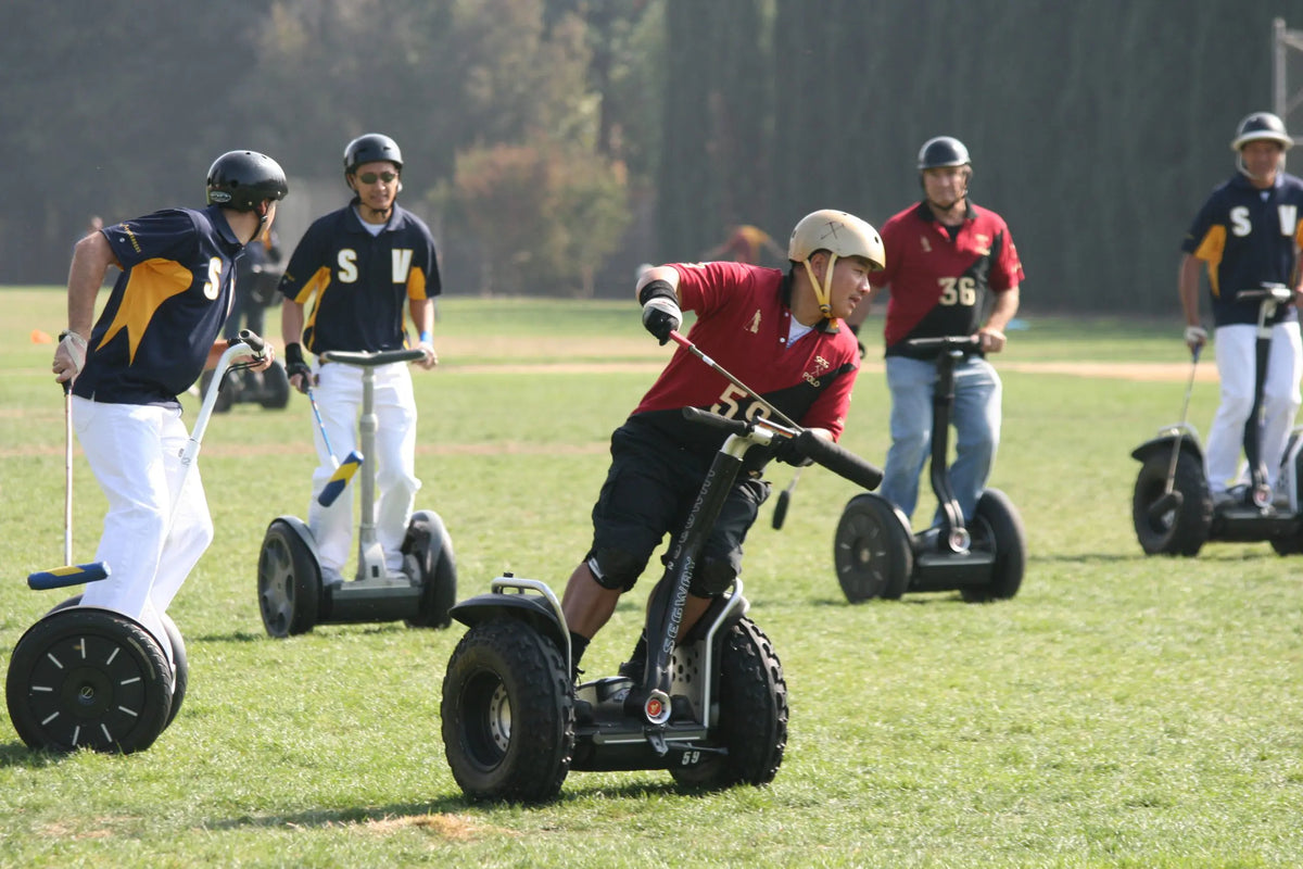 Joueurs de polo sur gyropodes Segway i2 XE sur un terrain herbeux